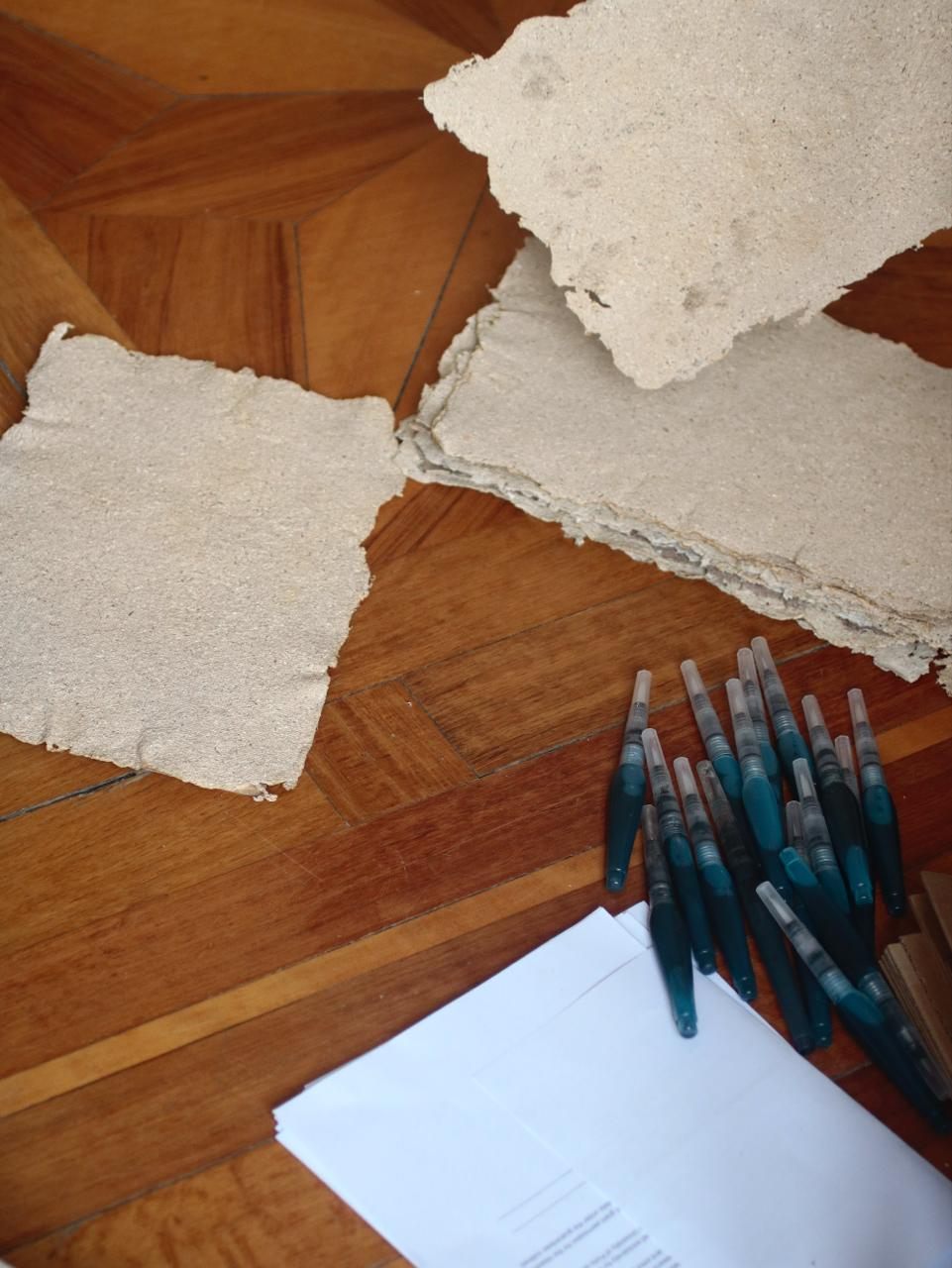 Handmade mycelium paper and pens laid on the floor