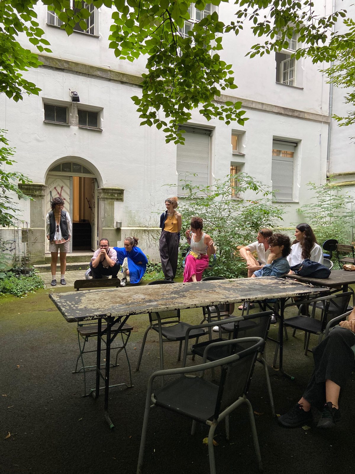 Audience seated around folding tables in the courtyard