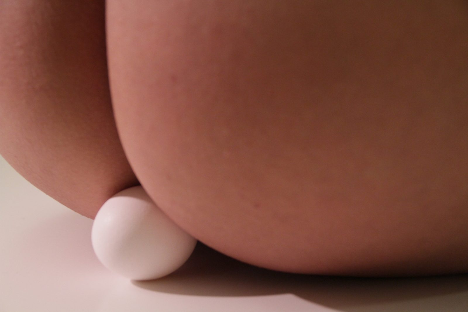 An egg resting between two thighs, close up