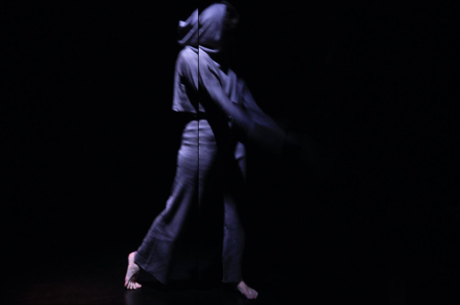 A figure walking in darkness, motion blurred